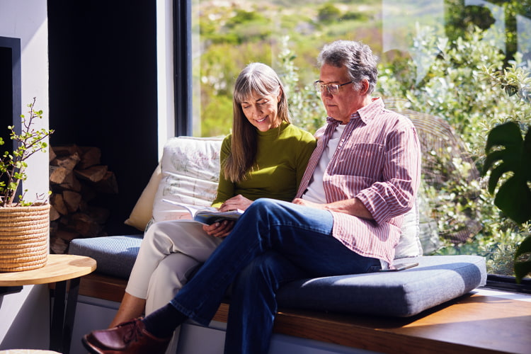 Wealth management image of happy couple reading a book