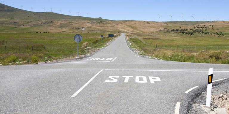 Intersection of a roads crossing surrounded by green fields